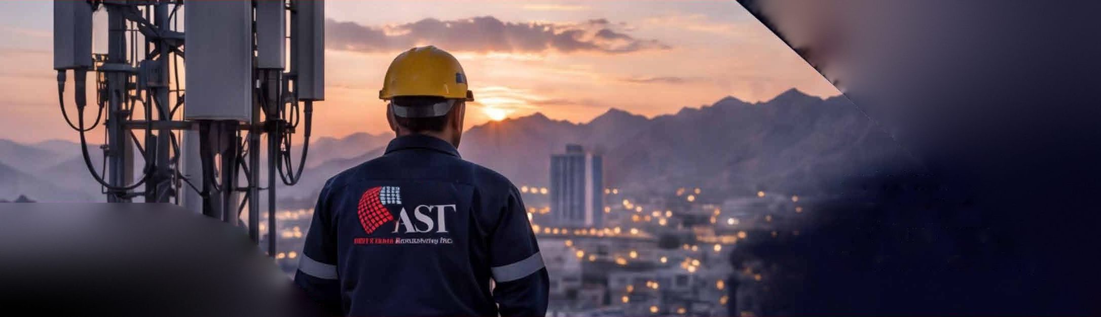 مهندس من ⁨AST⁩ يطل على مسقط عند الغروب بجوار صاري اتصالات